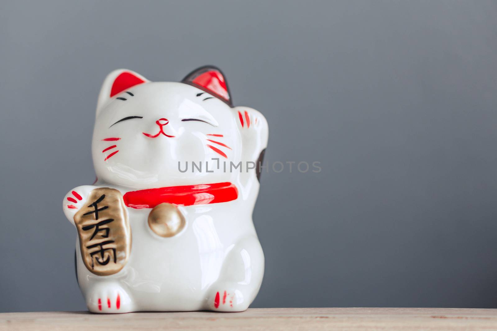 Maneki neko lucky cat show text on hand meaning rich on wood tab by pt.pongsak@gmail.com