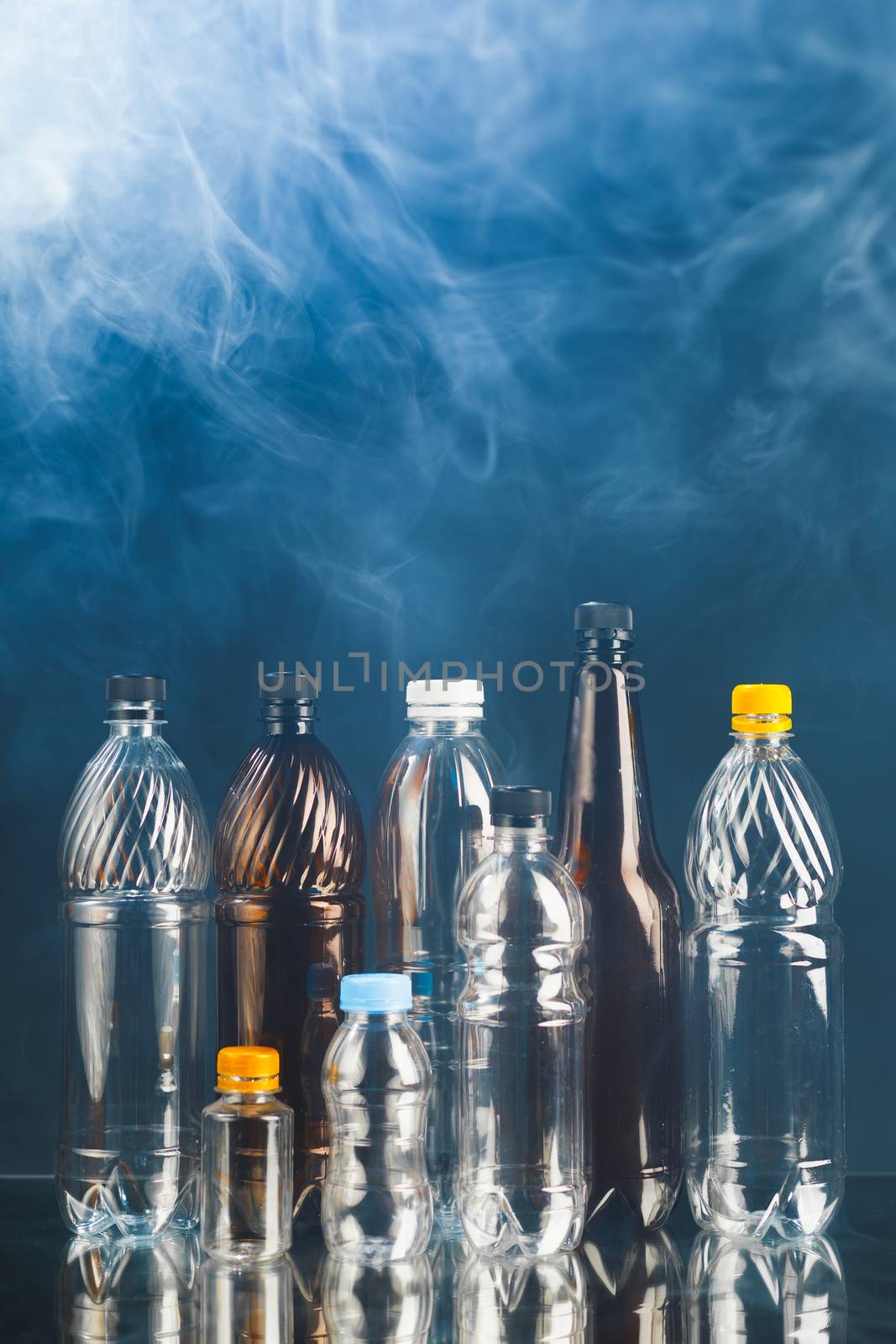 variety of plastic bottles in smoke, pollution concept by nikkytok