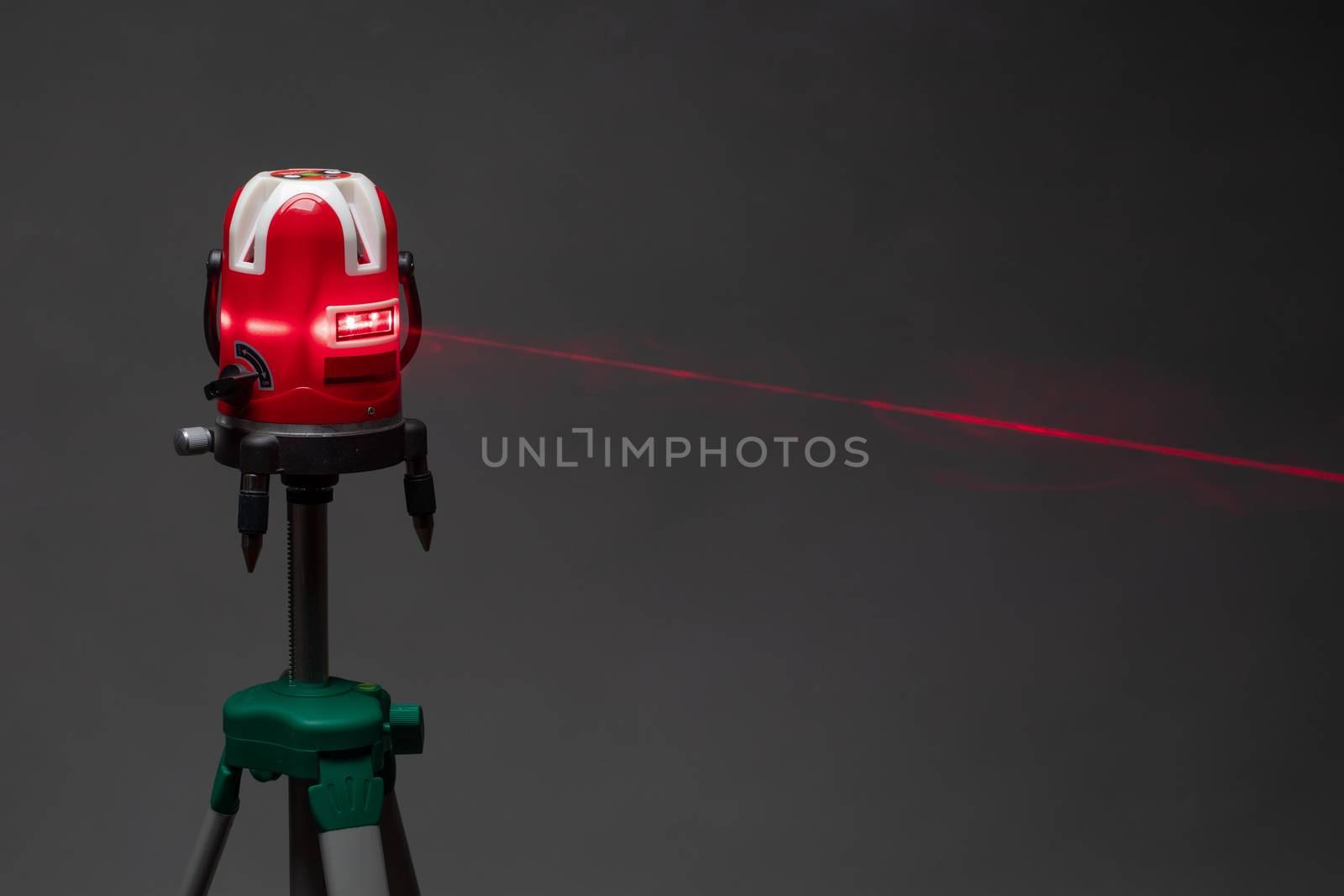 laser level tool red light beam, grey background with copy-space