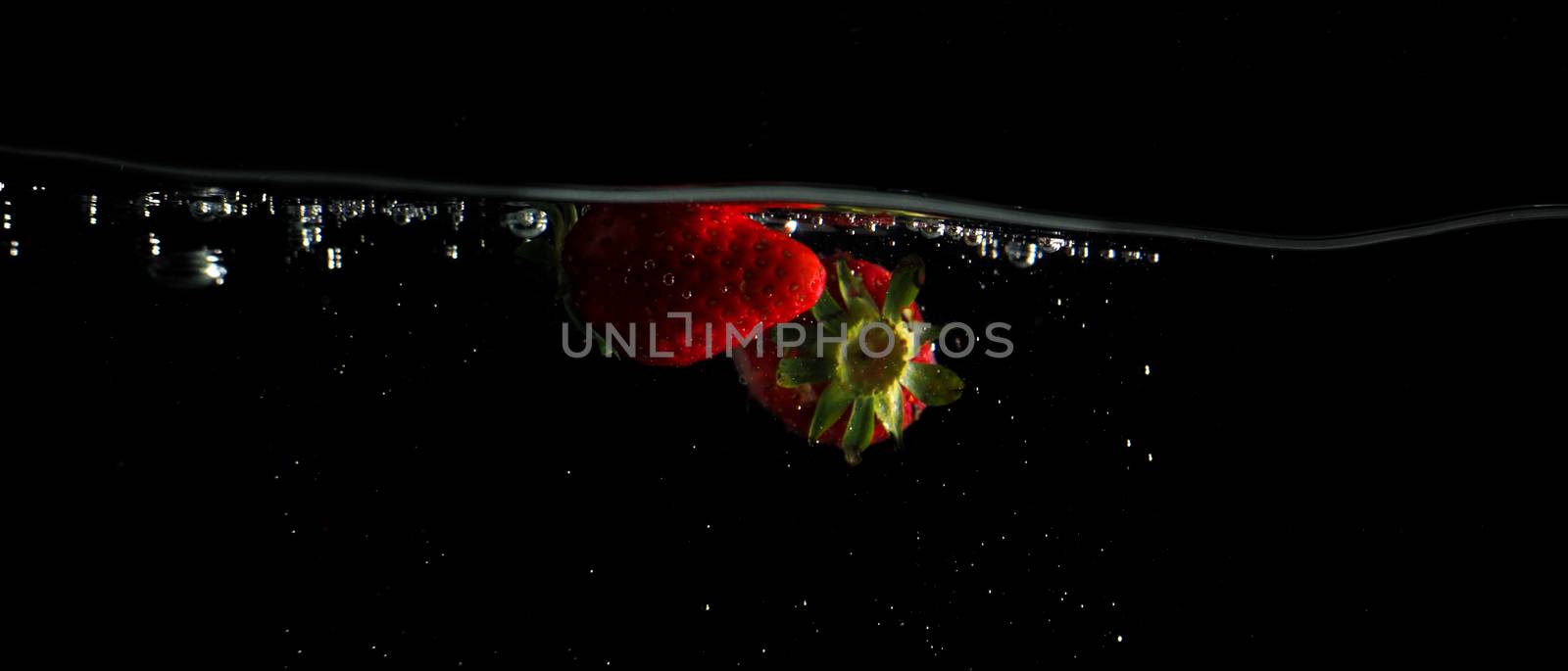 Fruit falling to water splash black background by gnepphoto
