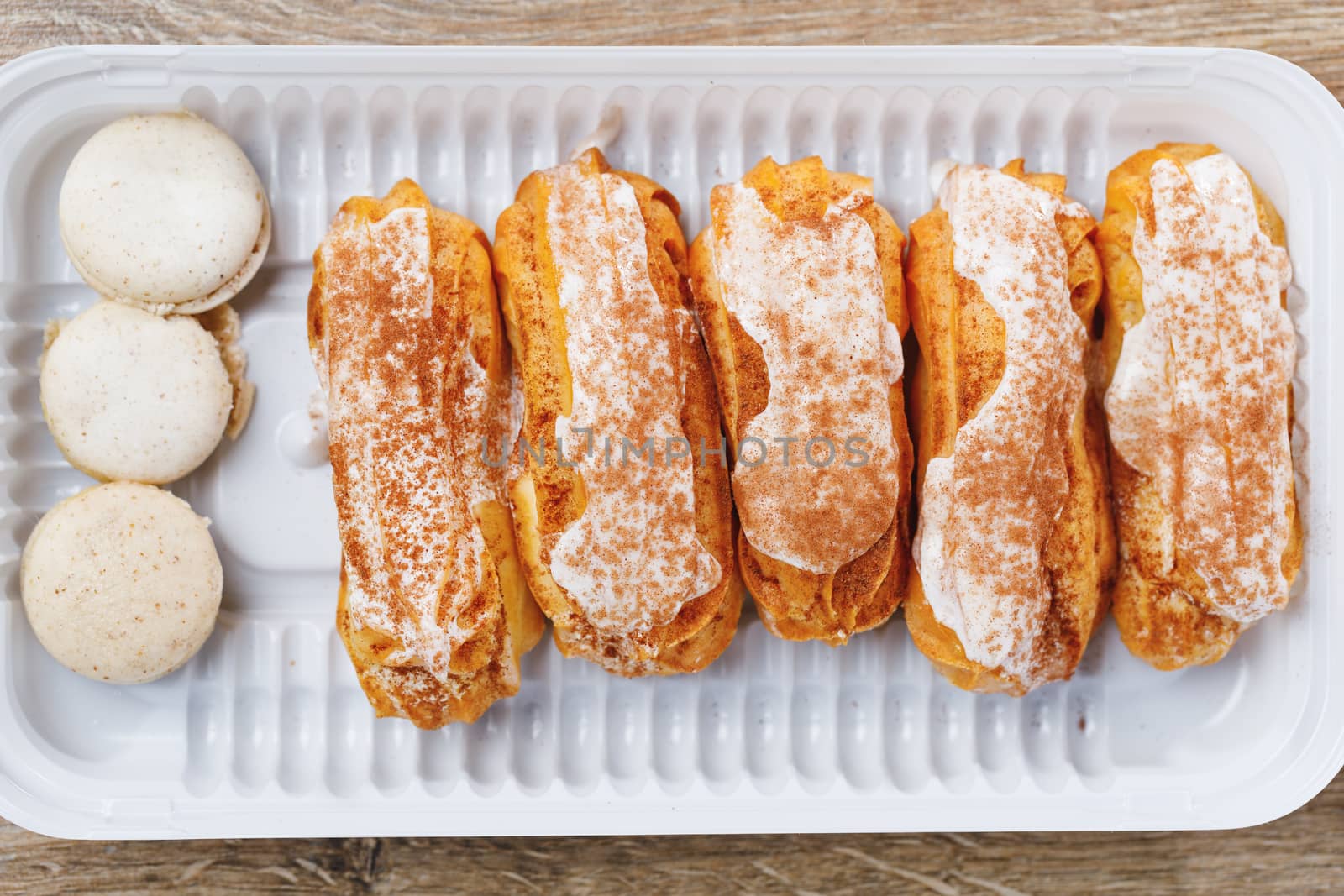 eclairs pastry on a plastic tray, close-up view