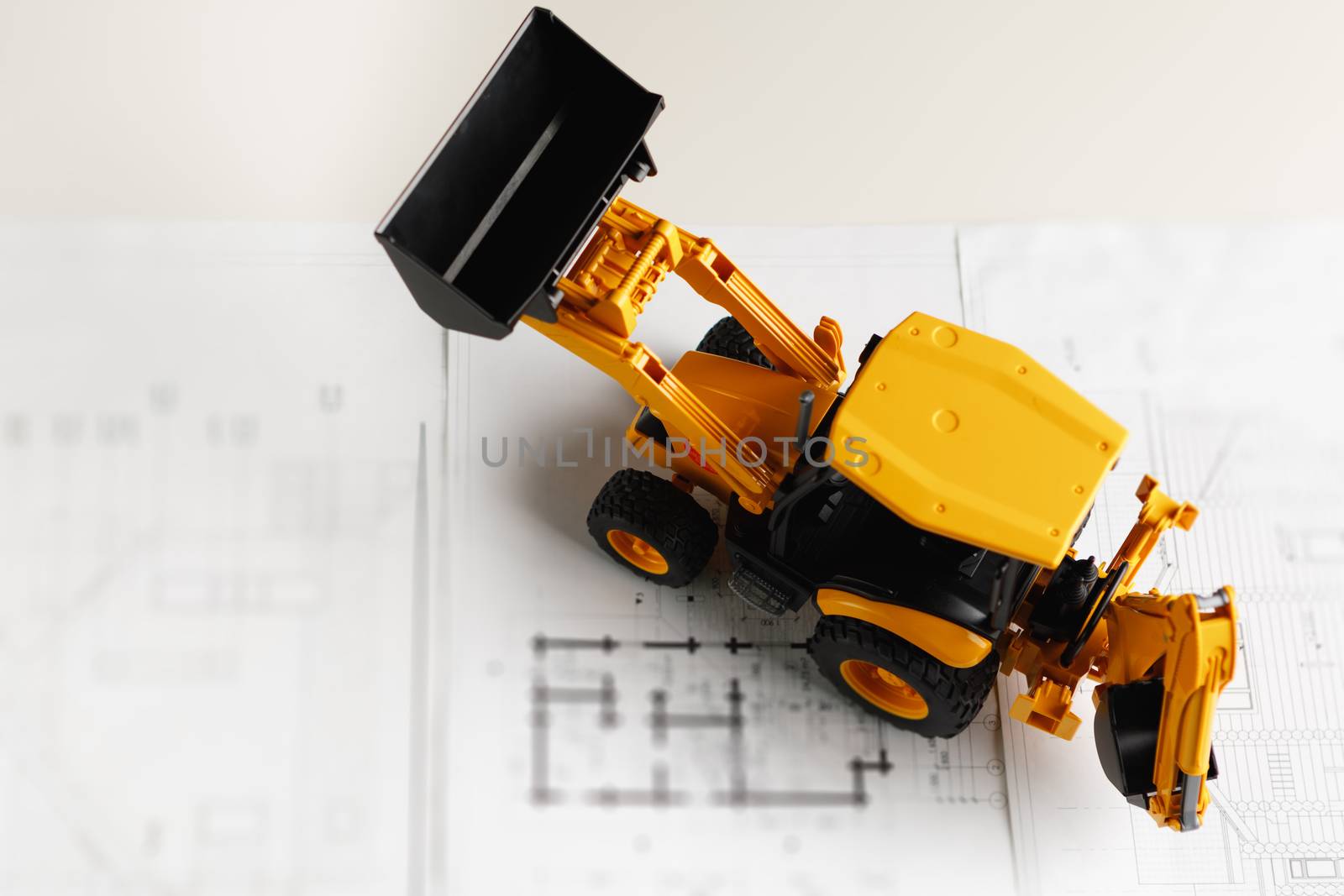tractor toy on housing construction blueprint by nikkytok