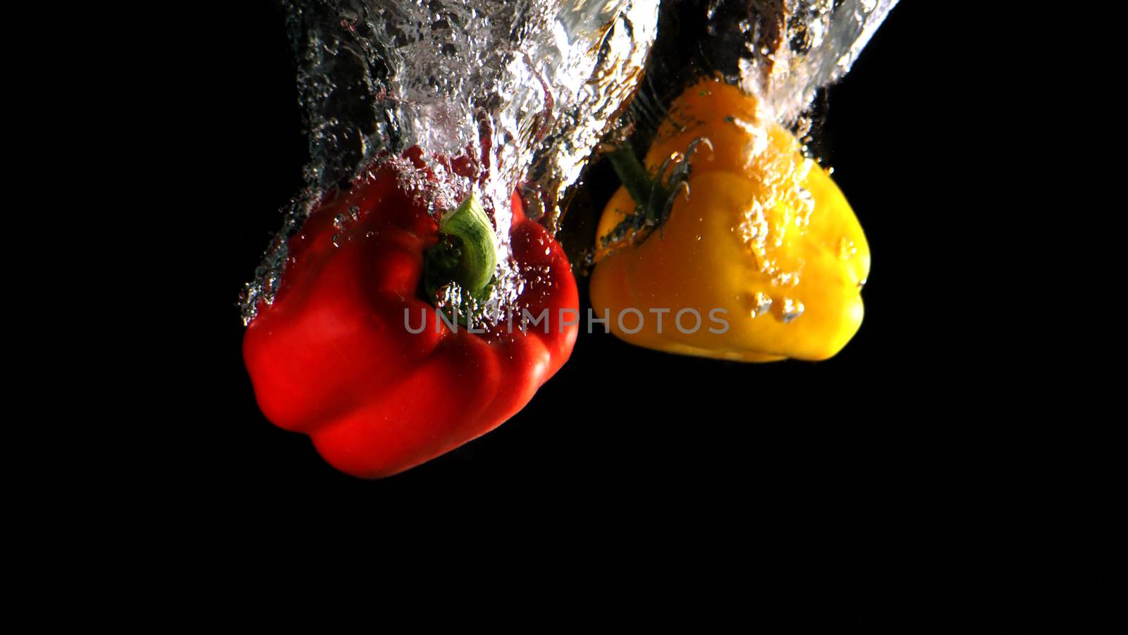 Colorful fresh vegetable cleaning by drop in to water splash and black background.