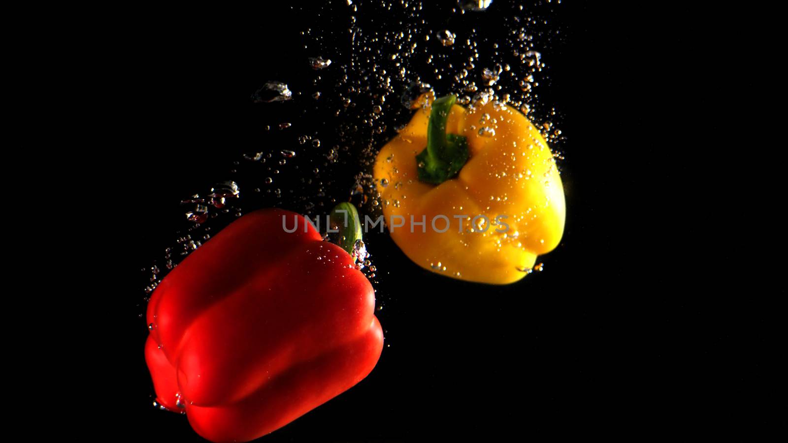 Colorful fresh vegetable cleaning by drop in to water splash and black background.