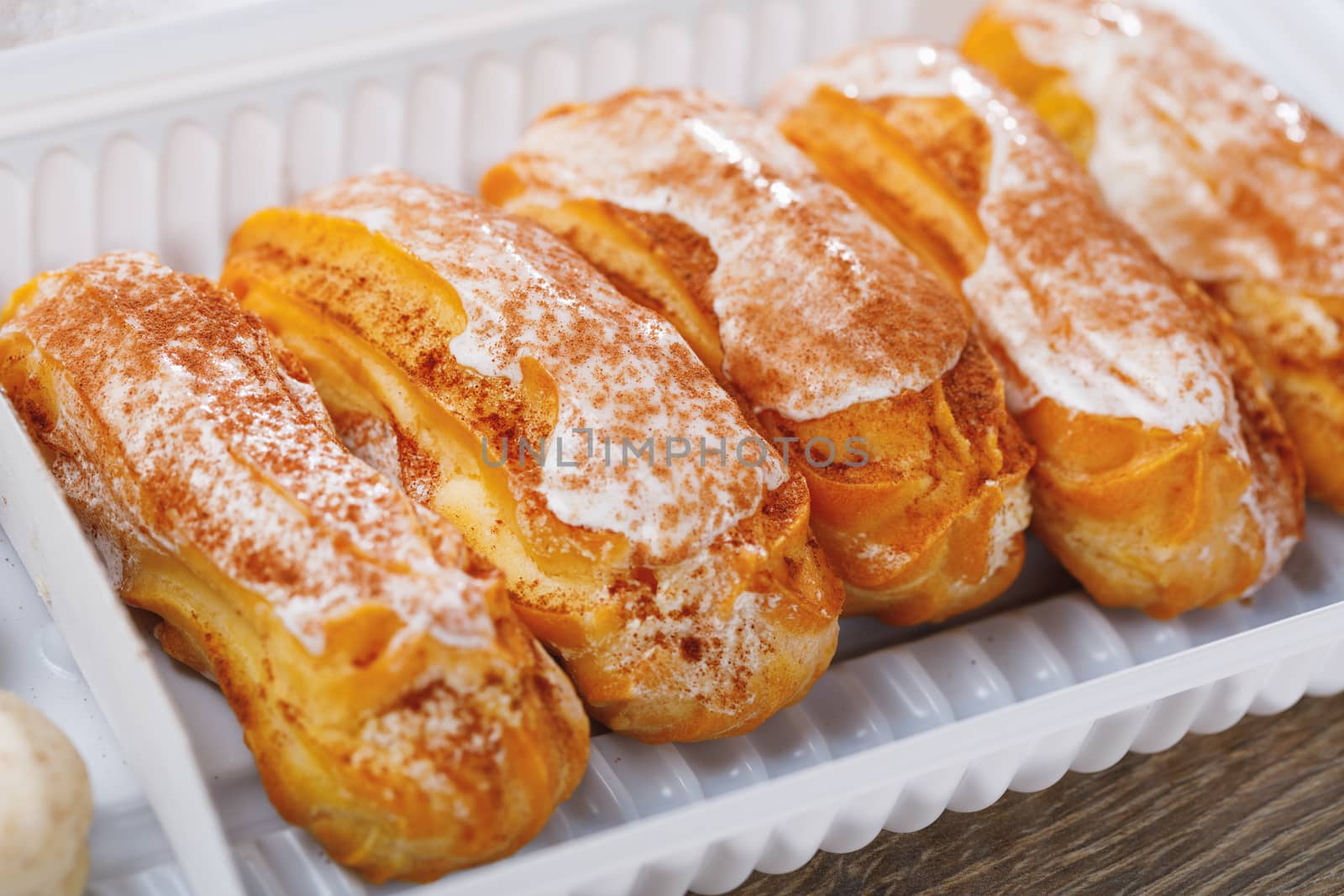 eclairs pastry in a plastic box, close-up view