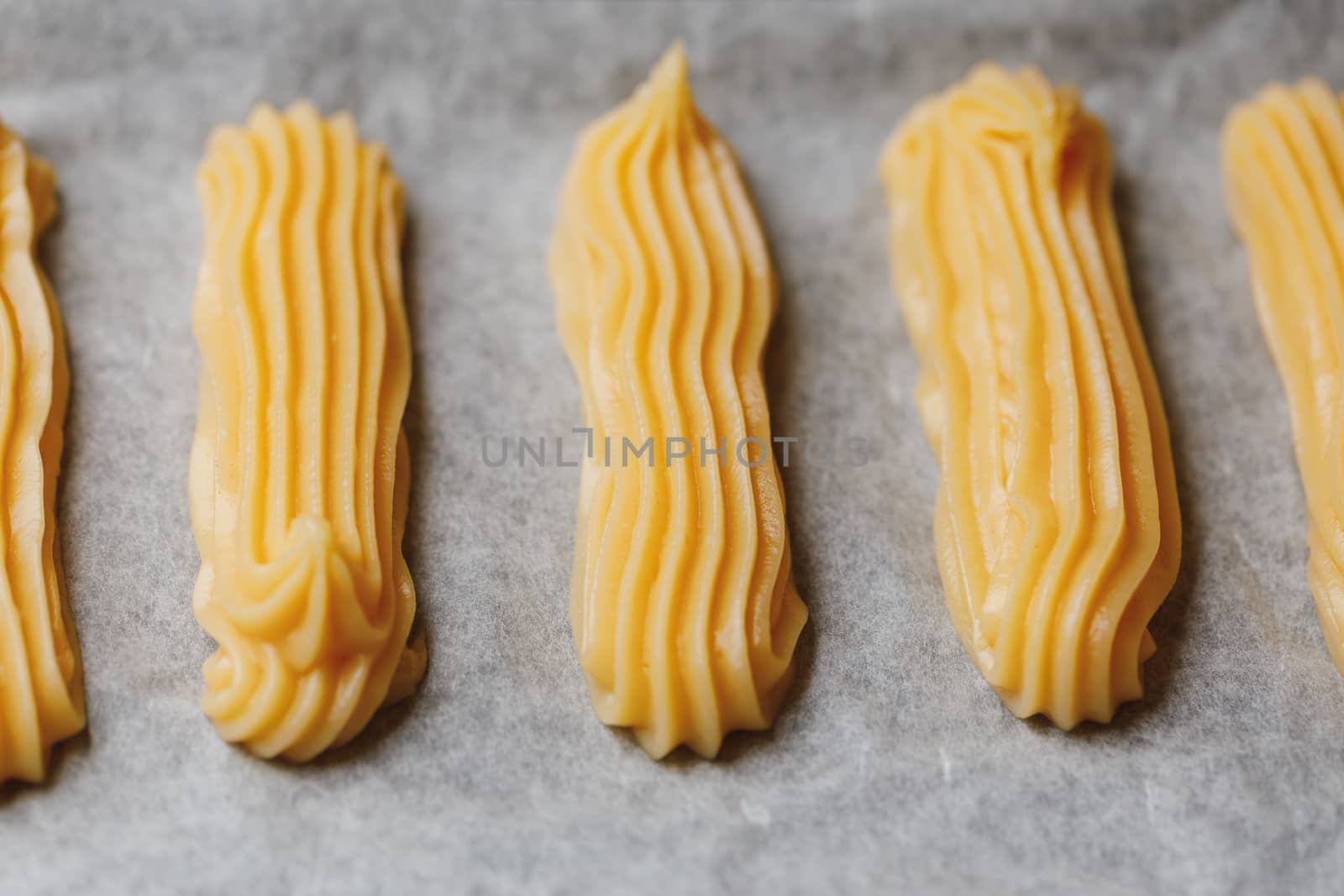 raw eclairs choux pastry on the baking tray