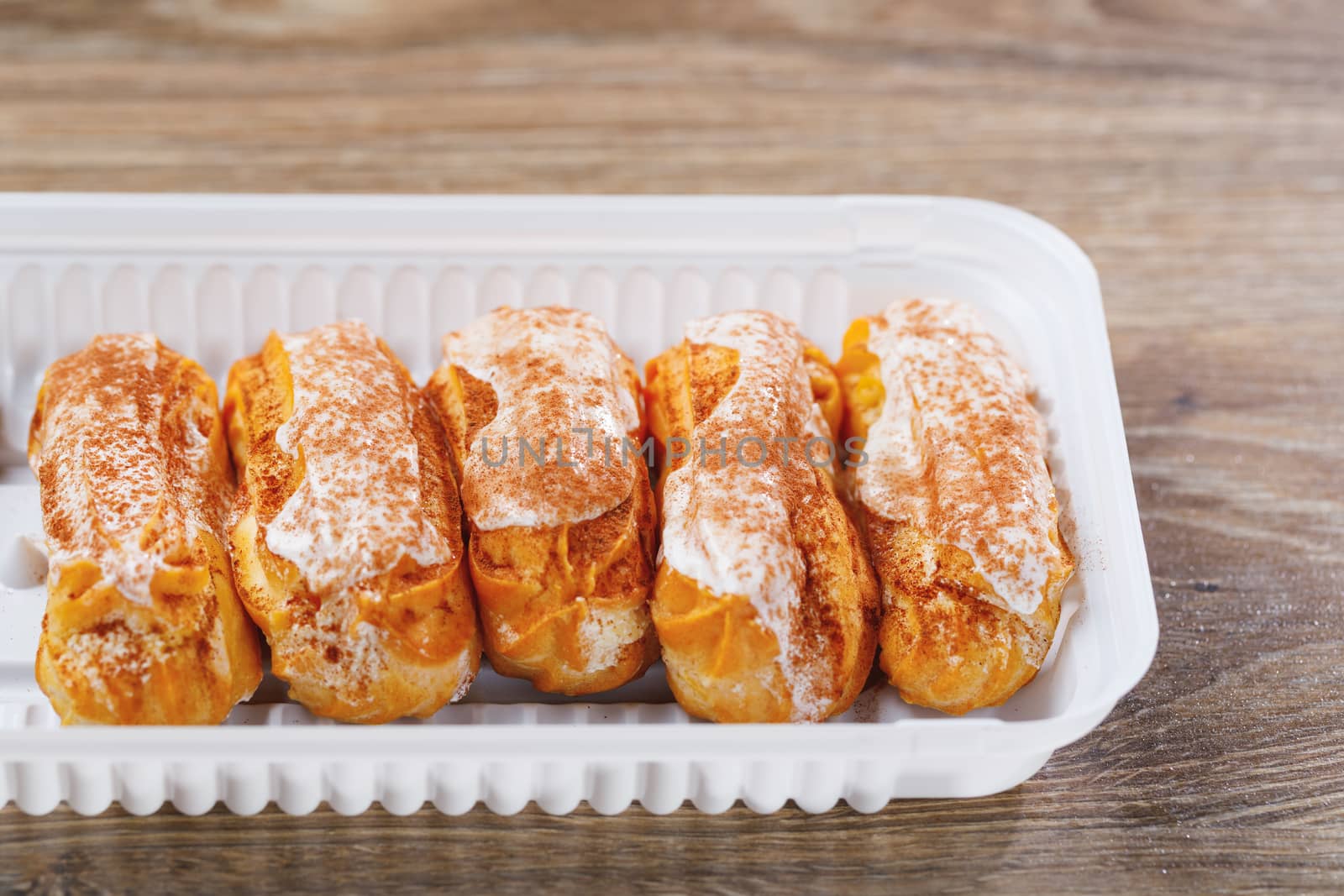 eclairs pastry in a plastic box, close-up view