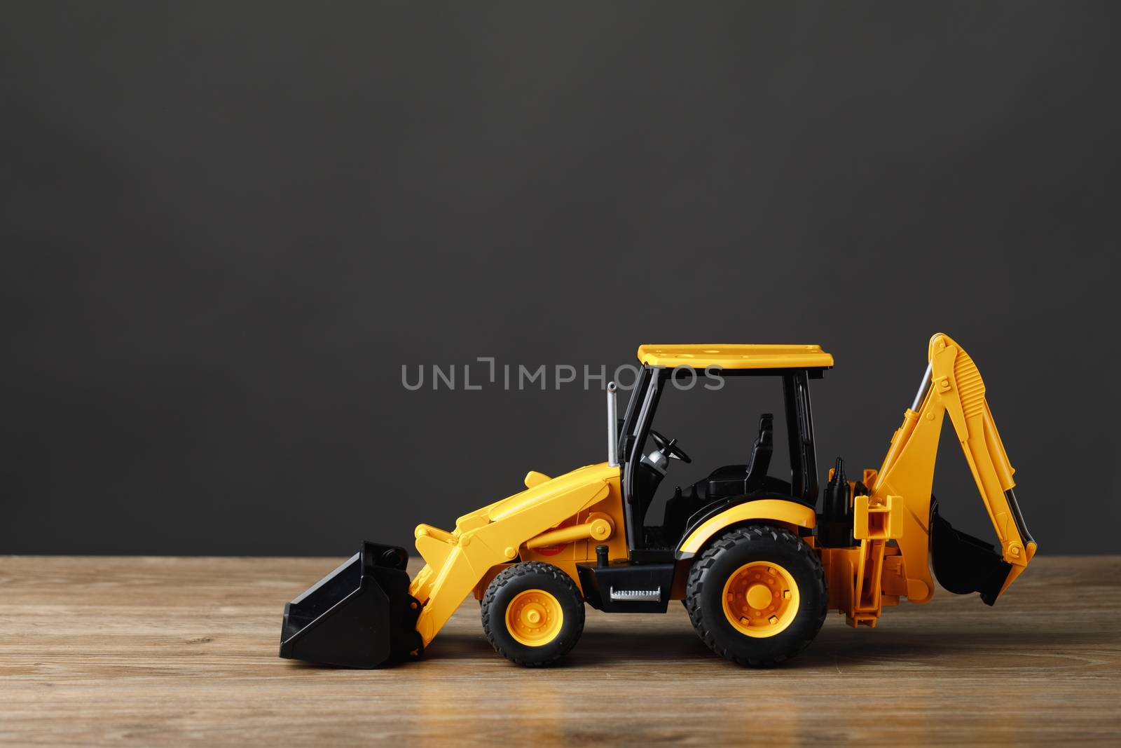 backhoe tractor toy, gray background