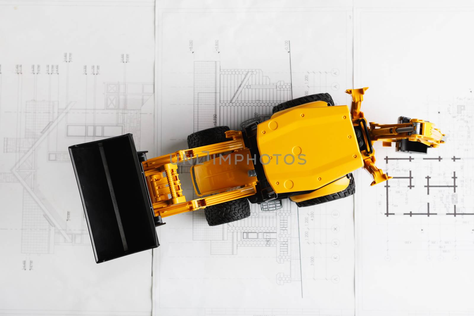 tractor toy on housing construction blueprint by nikkytok