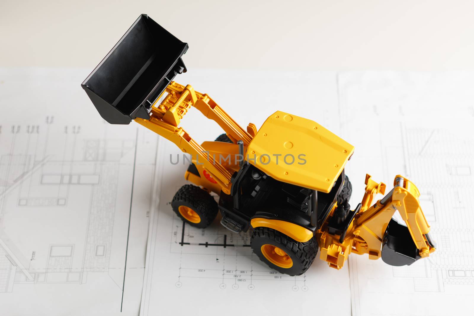 tractor toy on housing construction blueprint