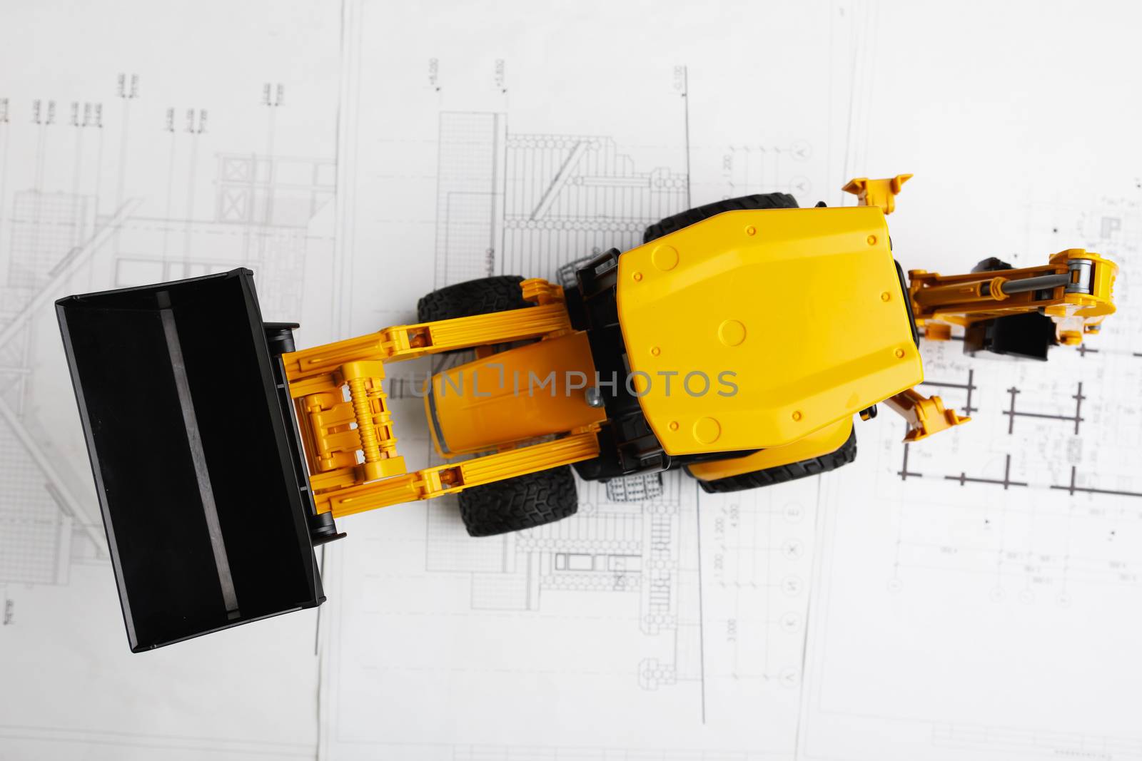 tractor toy on housing construction blueprint by nikkytok