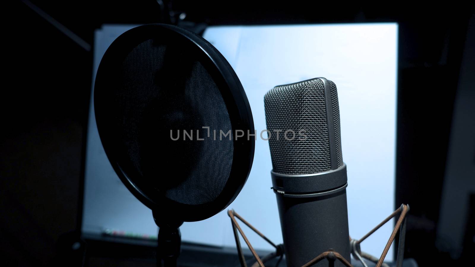 Microphone with pop filter and shock mount anti-vibration and note stand and tripod in music score studio production