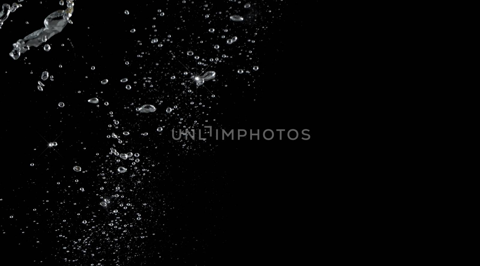 Soda water bubbles splashing and floating drop in black background represent sparkling and refreshing