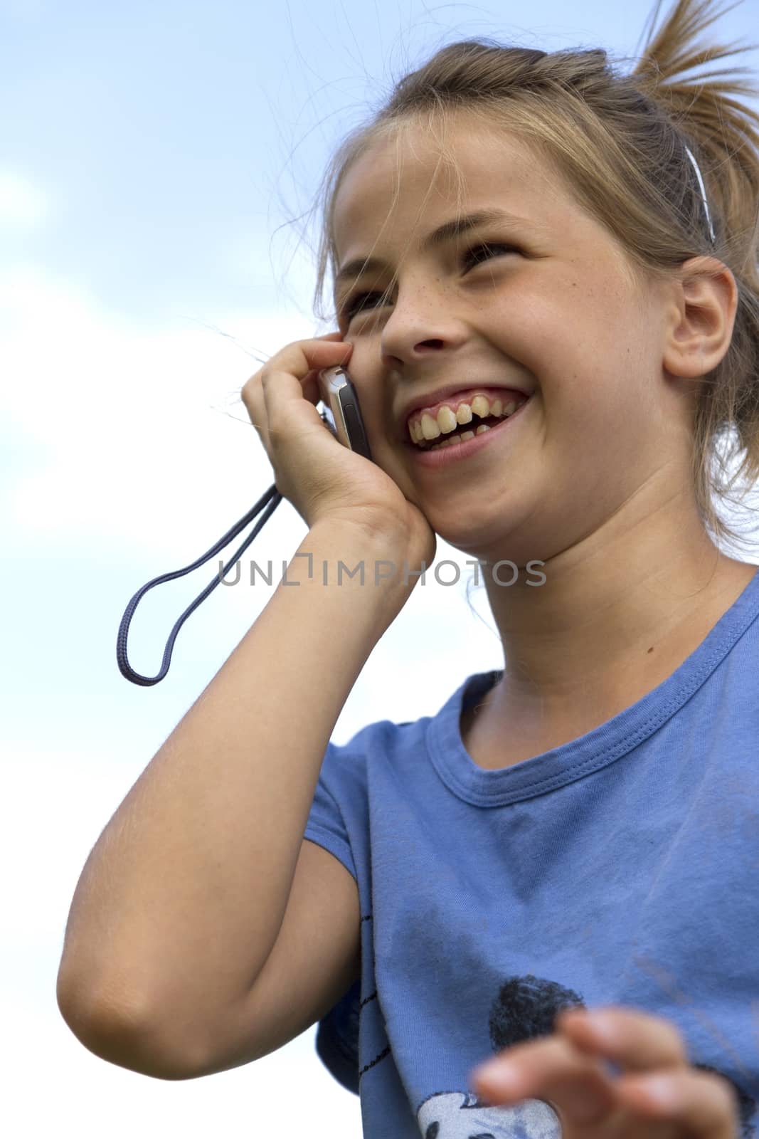 Happy girl while speaking with mobile telephone by Digoarpi