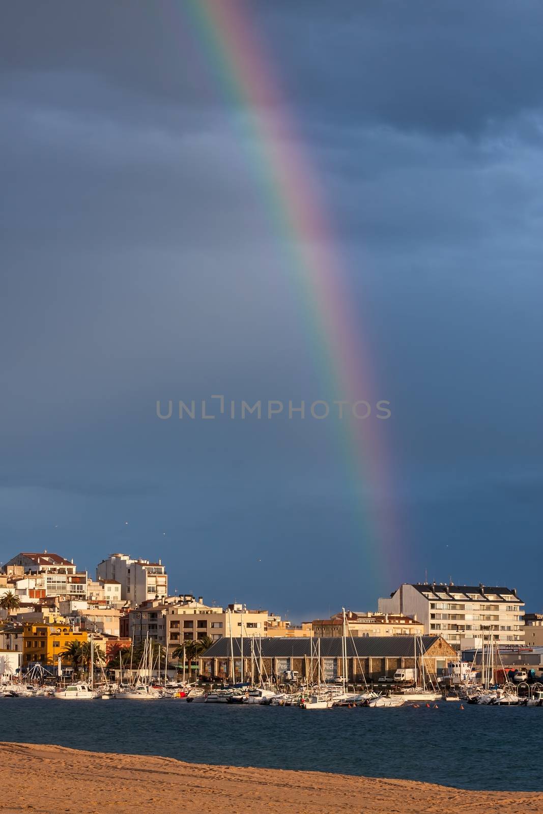 Beautiful rainbow over small town (Palamos)  in Spain