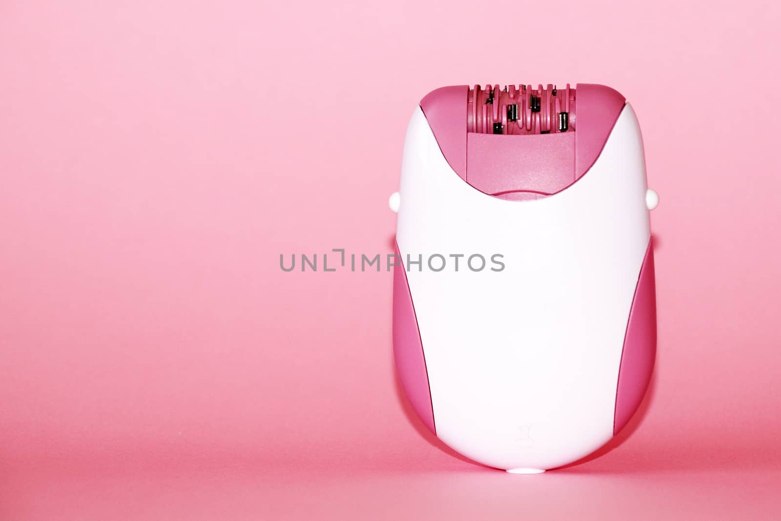 electric handheld epilator on pink background close up, copy space by Annado