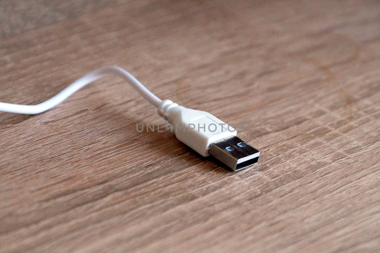 white usb cable on a wooden table close-up