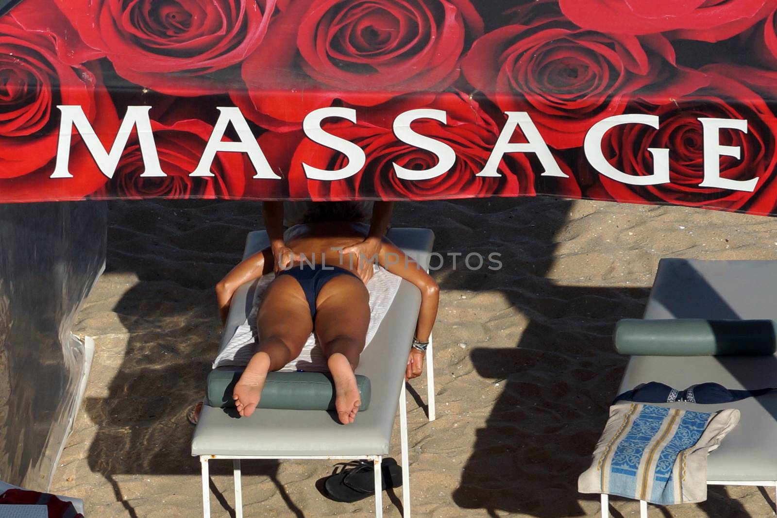Varna, Bulgaria - August, 16, 2020: Masseuse massages woman in tent on the beach