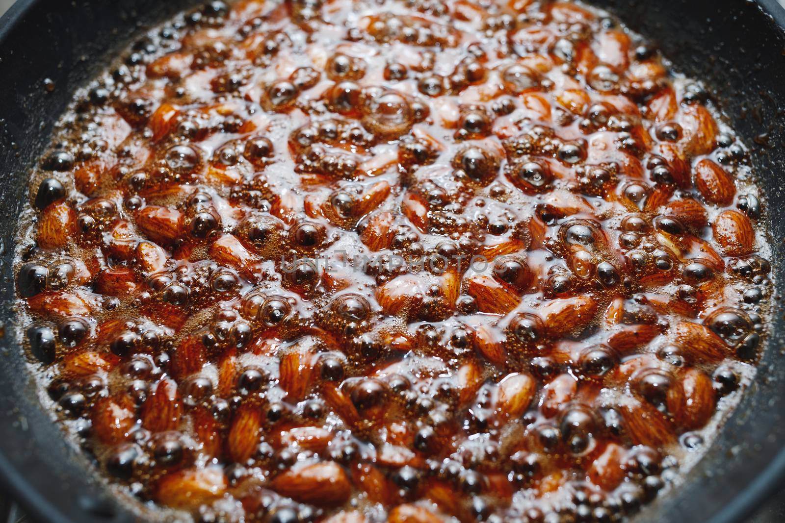 roasted almonds with cinnamon sugar cooking process, close-up view