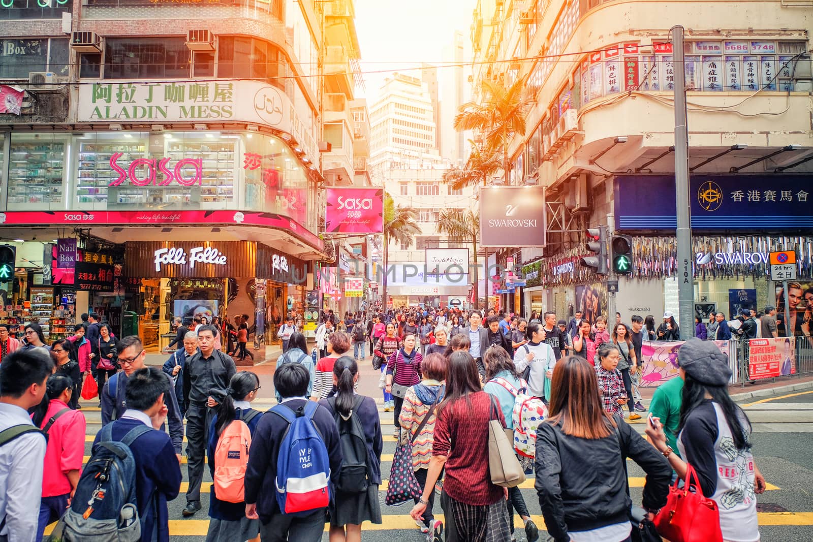 HONG KONG - March 13 2017: People walking across Road, Causeway Bay in front of a big department store at Daylight. Hong Kong March 13, 2017