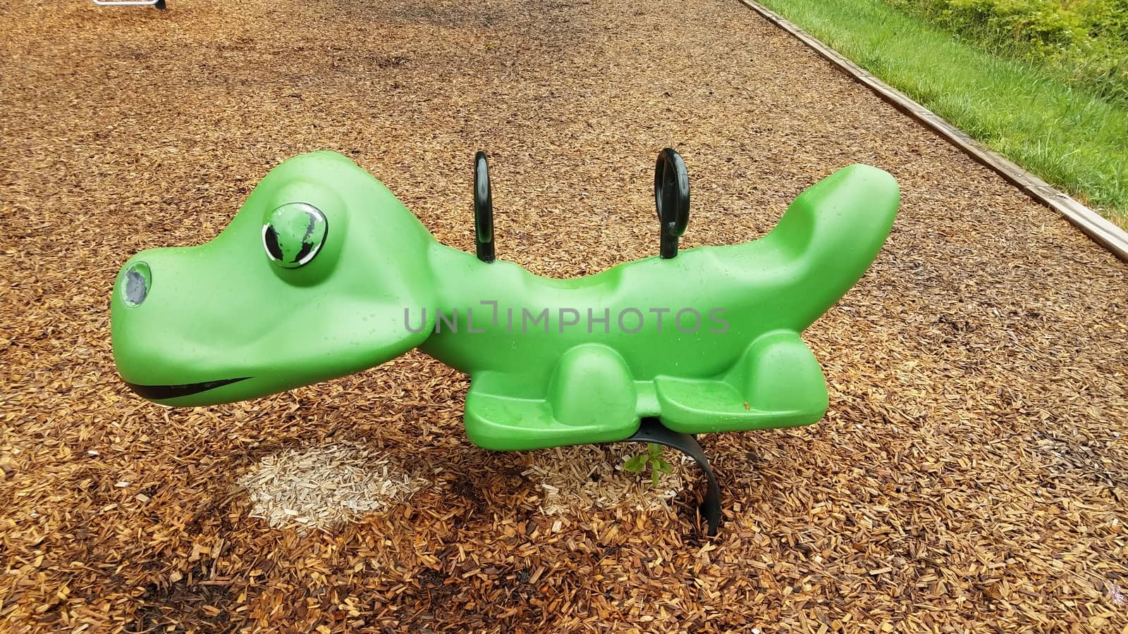 wet green playground equipment or ride at park by stockphotofan1