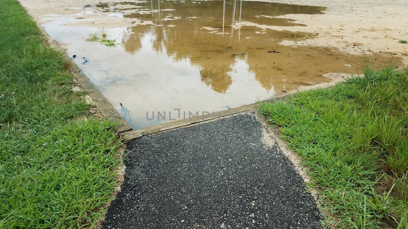 path to sand in volleyball court with large water puddle