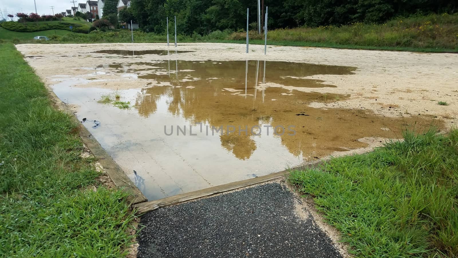 path to sand in volleyball court with large water puddle