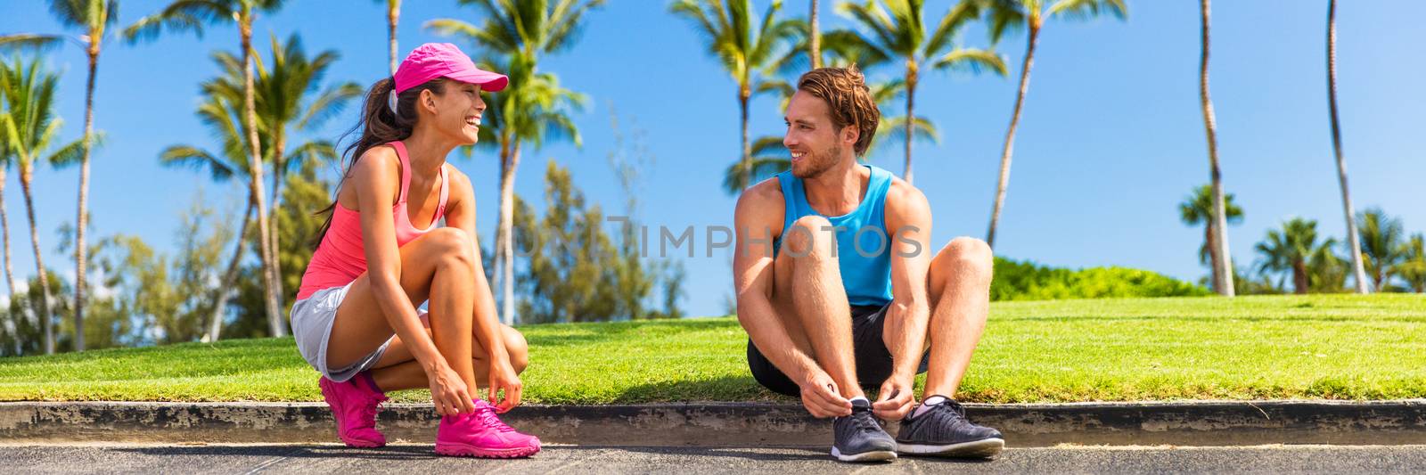 Runners couple tying running shoes to run banner. Runner woman and athlete man lacing shoe laces at park. Healthy lifestyle jogging motivation, happy healthy people. Horizontal landscape crop.