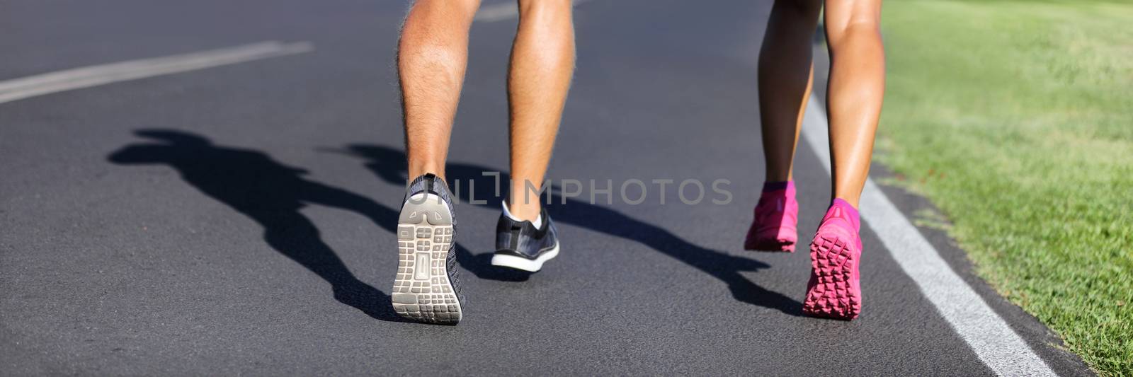 Fitness runners running road to weight loss banner - couple of young people jogging together - crop of legs and running shoes.