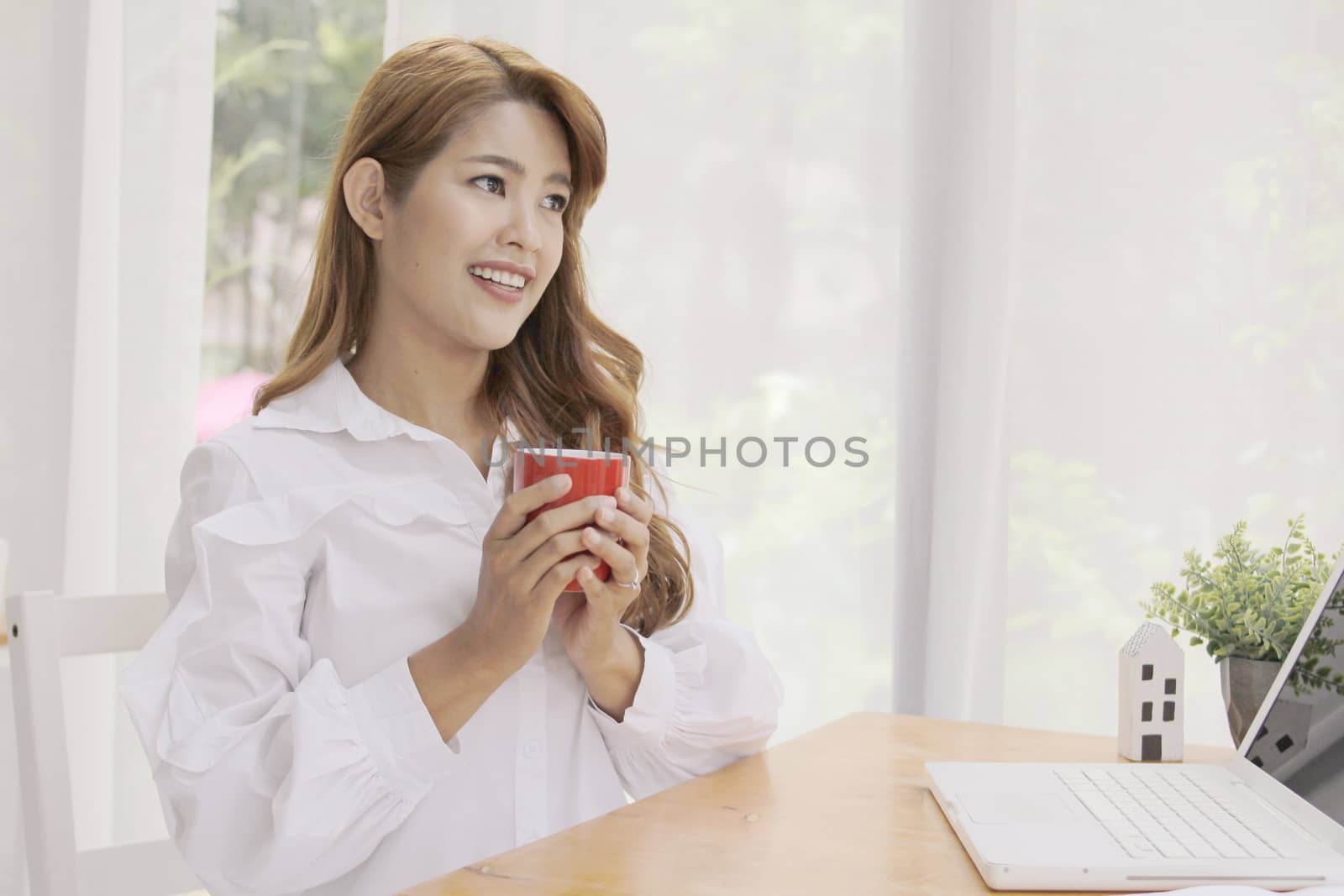 beautiful woman sitting in the bedroom with a cup of coffee