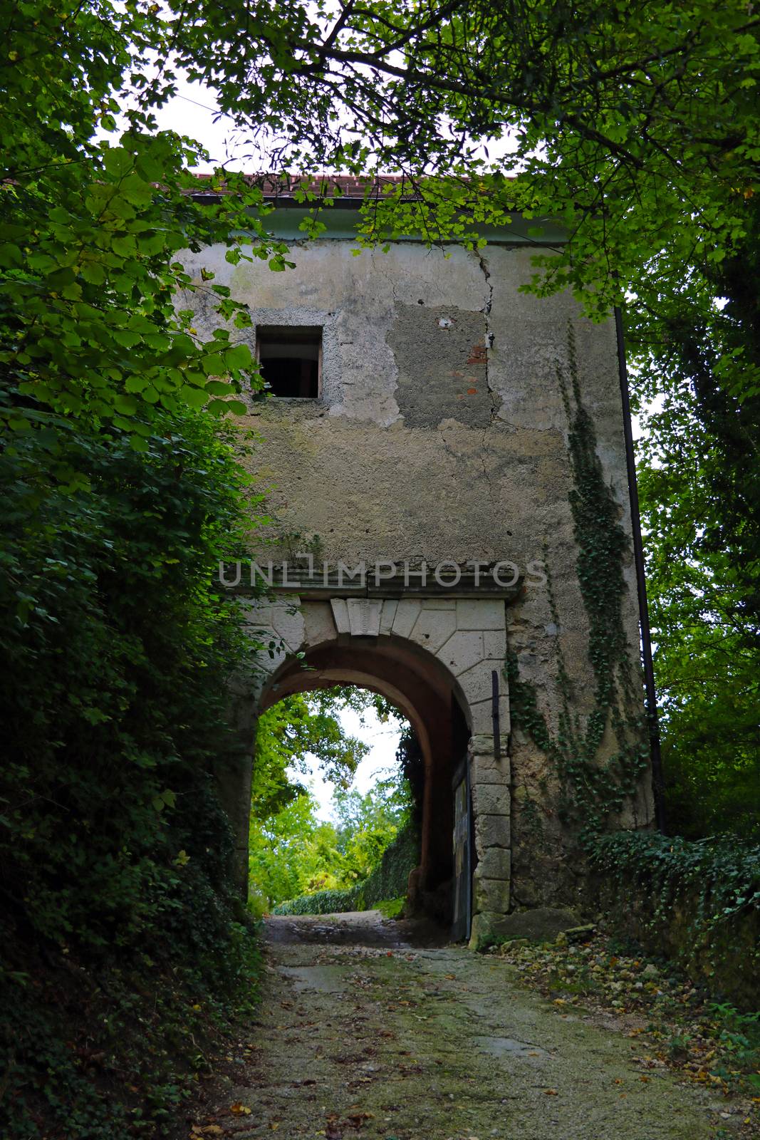 An old building with an arch for car passage