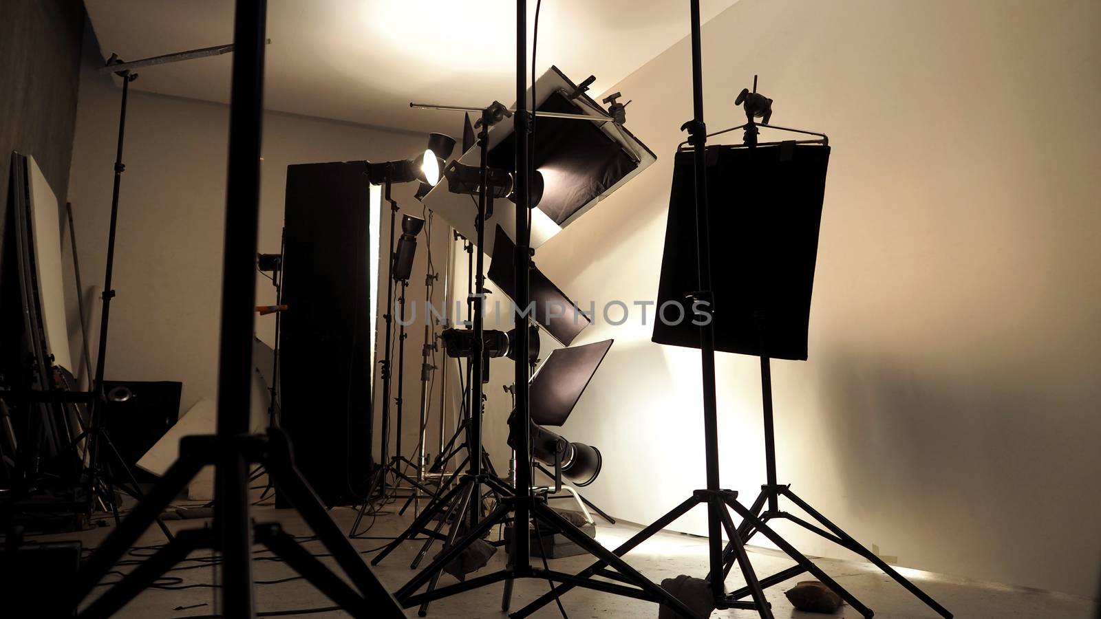 Lighting setup in studio for commercial works such as photo movie or video film production which use many LED light more than 1000 watts with big softbox snoot reflector umbrella and tripods. 