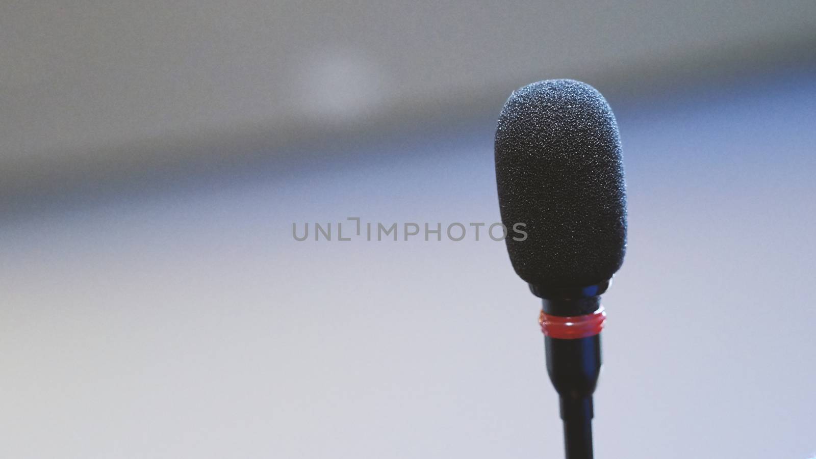 Mini microphone speaker in conference hall for speech in business seminar or organisation training or study and lecture and blurry images background.