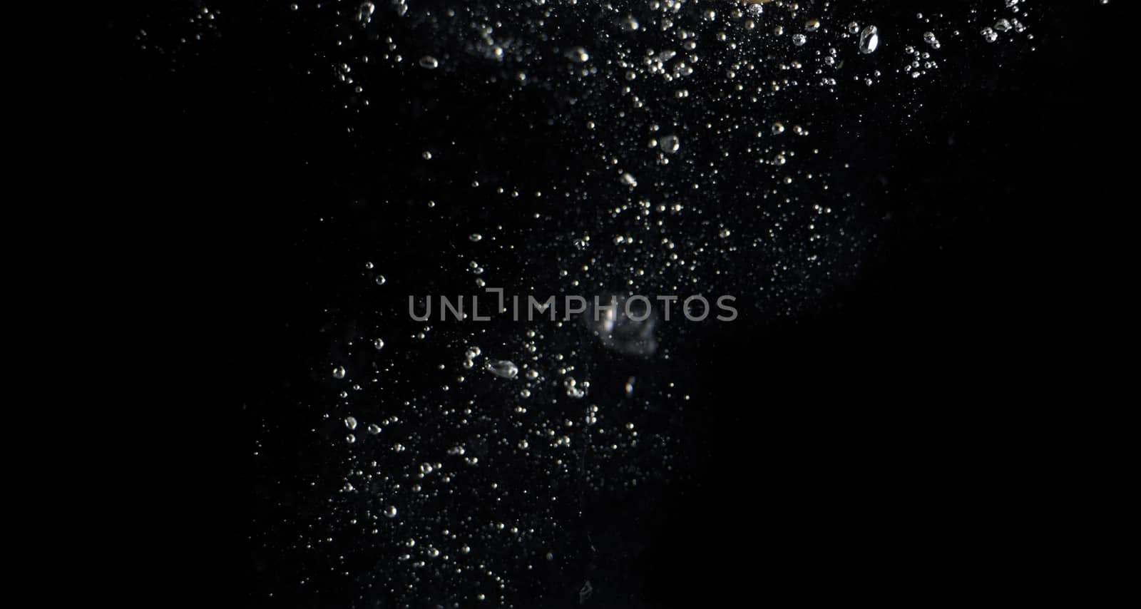 Blurry images of clear transperant soda liquid bubbles splashing or sparkling and moving up in black background for represent the refreshing moments after drink carbonated water.