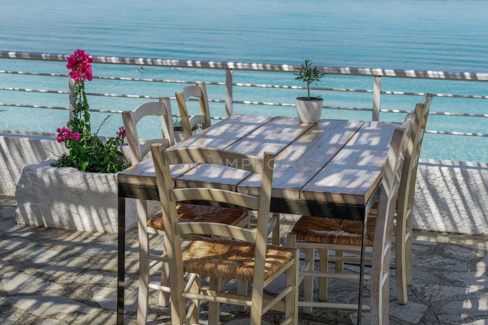 Restaurant outdoor seating area by the sea without customers in Kryopigi, Kassandra peninsula.