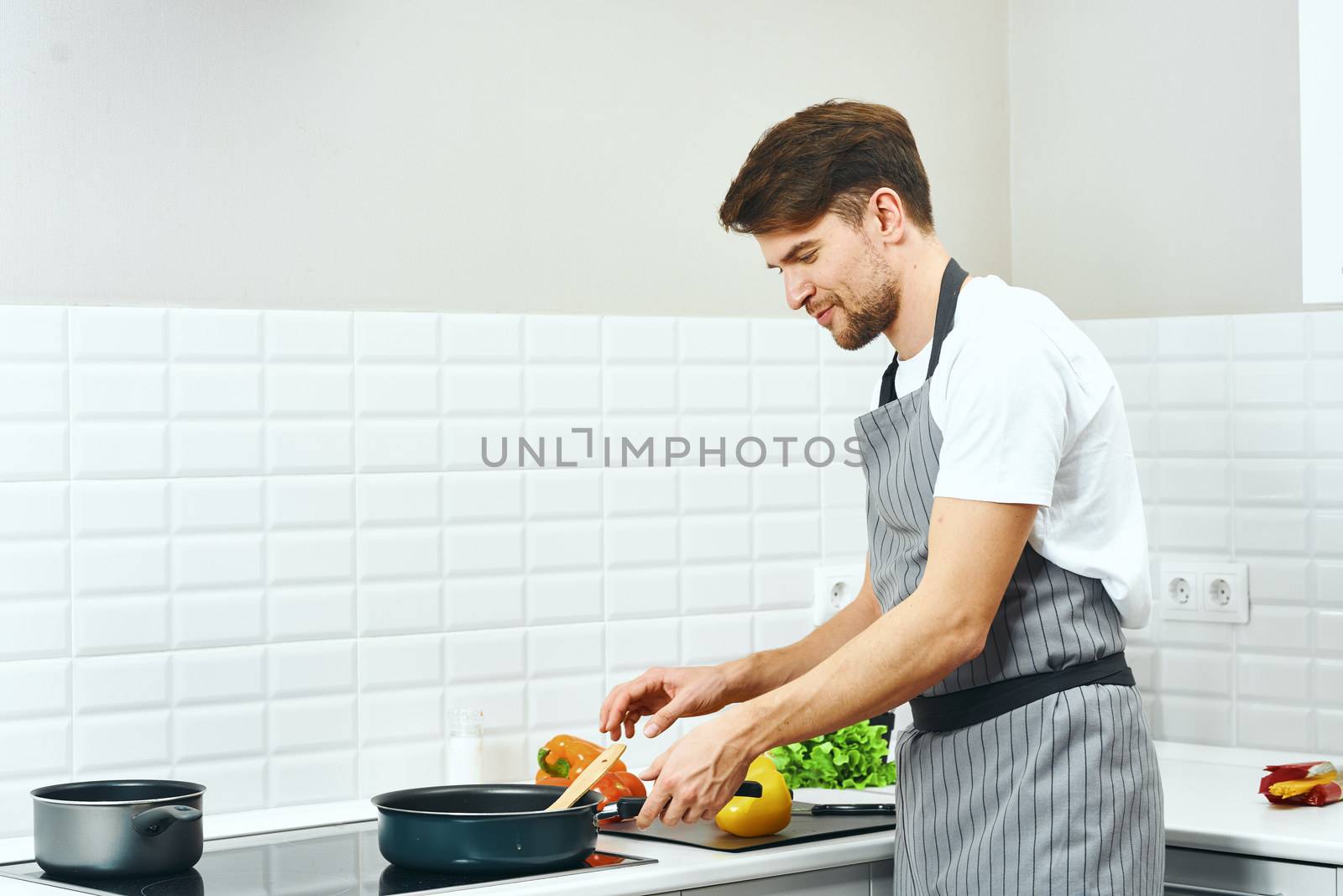 Male chef cashier aprons in the kitchen preparing food Professional recipe for food