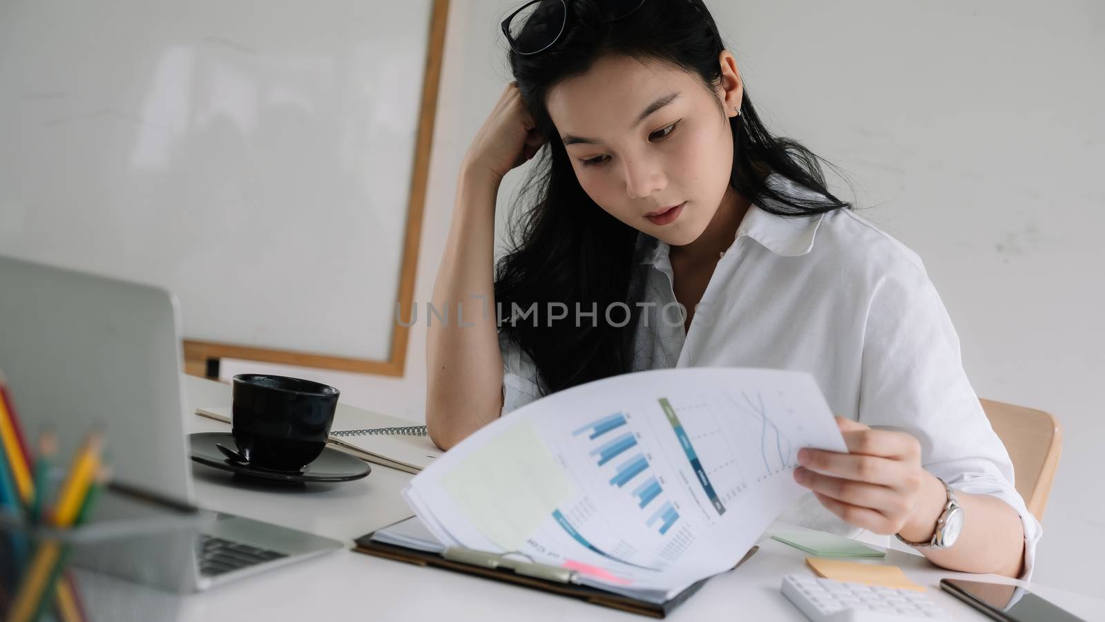 Serious focused businesswoman working with financial marketing report.