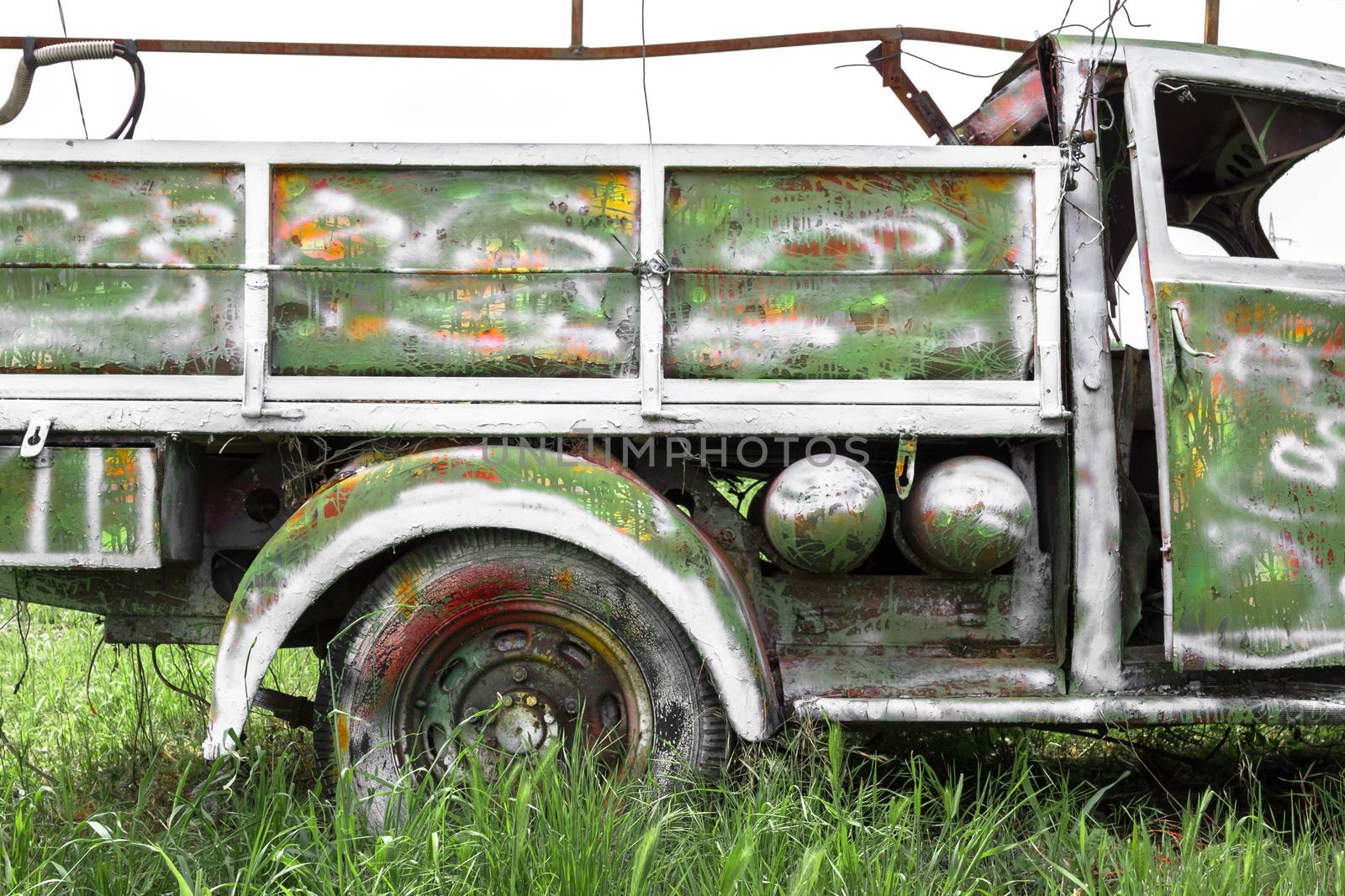 An old abandoned pickup truck, painted with bright colors.