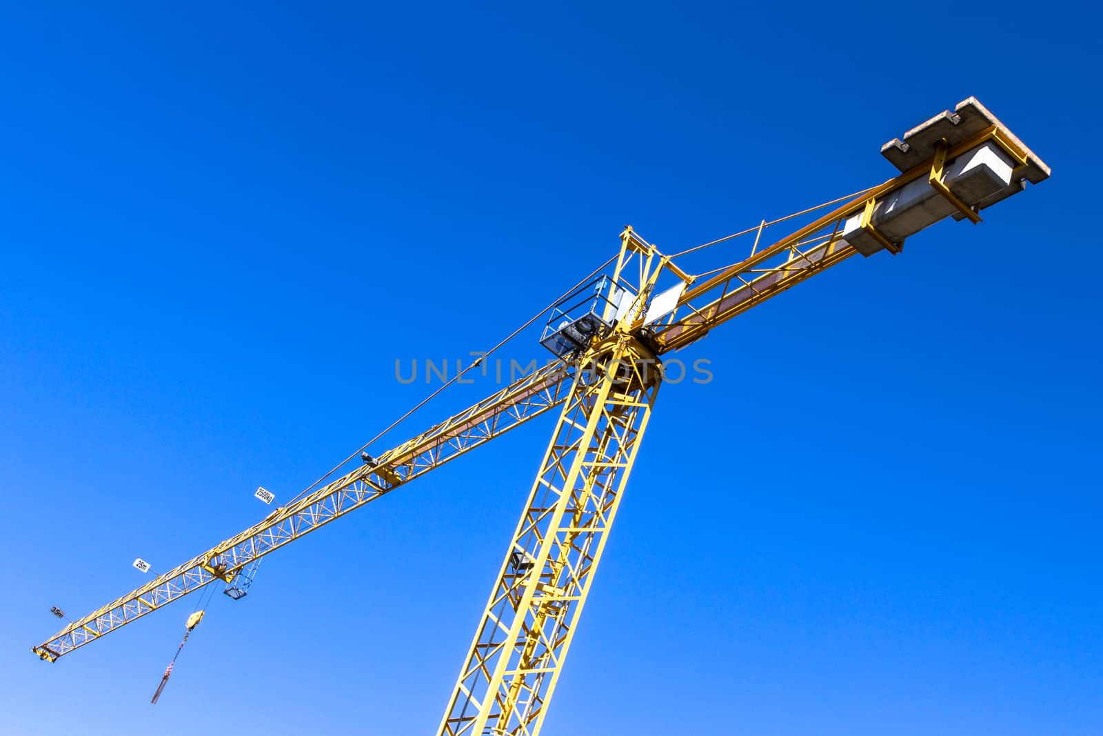 A yellow crane and a cobalt blue sky in the background.