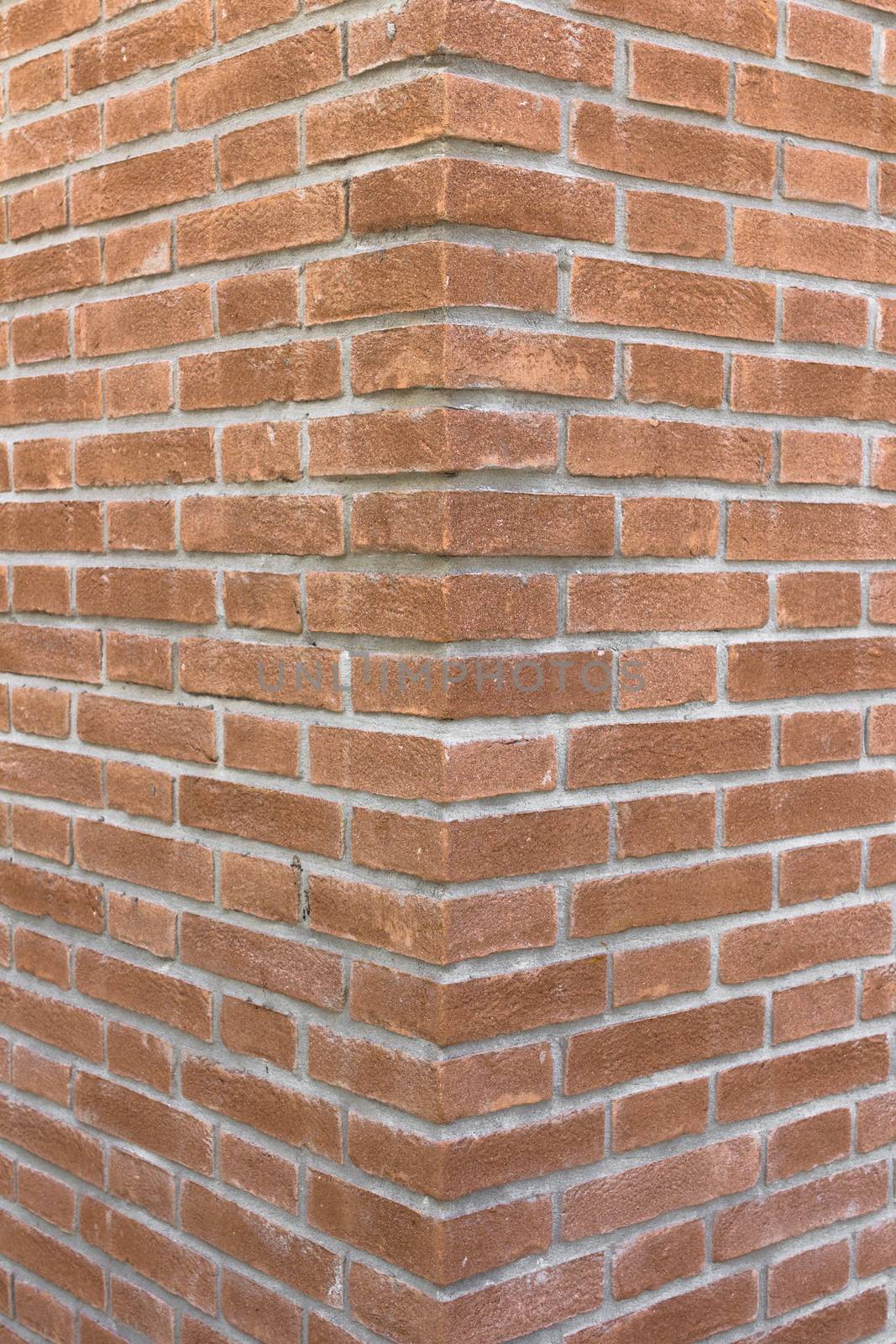Front view of a wall with bricks arranged in a regular mode.