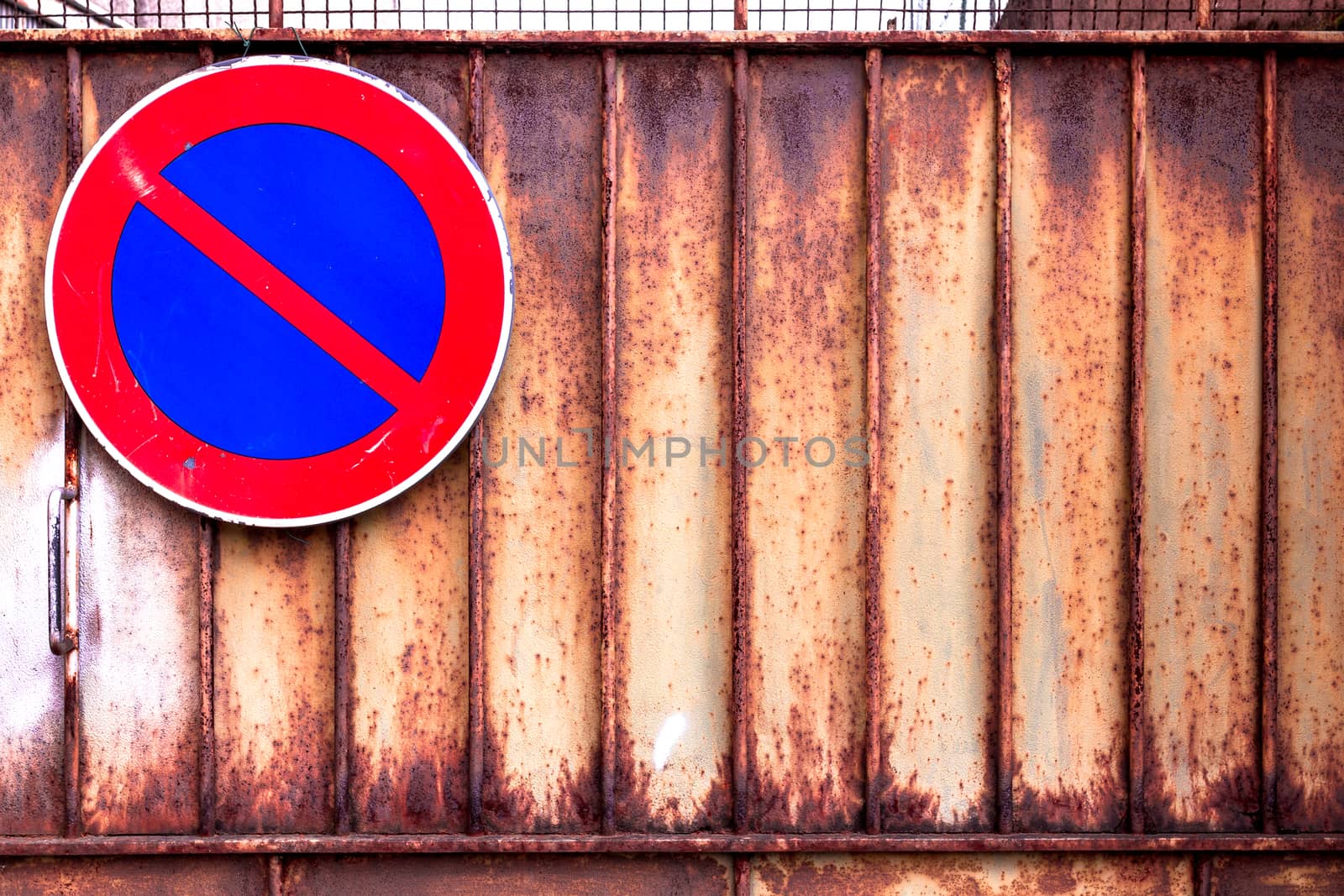 Signal of prohibition of parking on a rusty gate.