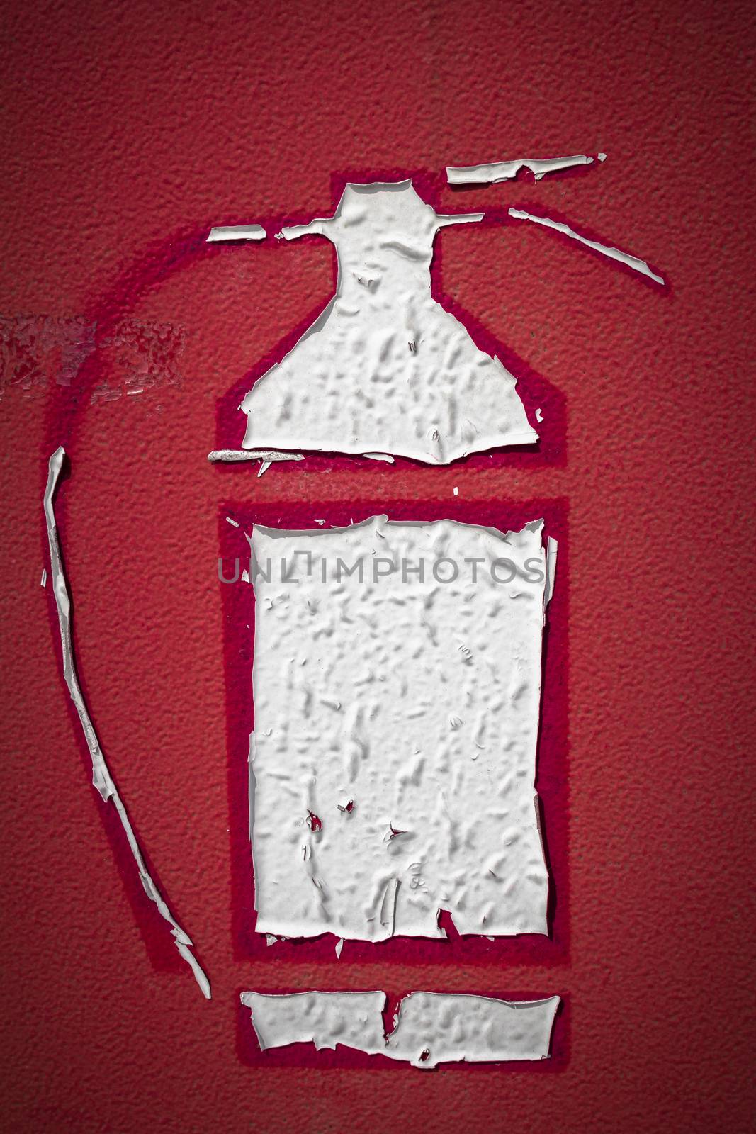 Sticker of a fire extinguisher icon deteriorated by the sun and by the elements.
