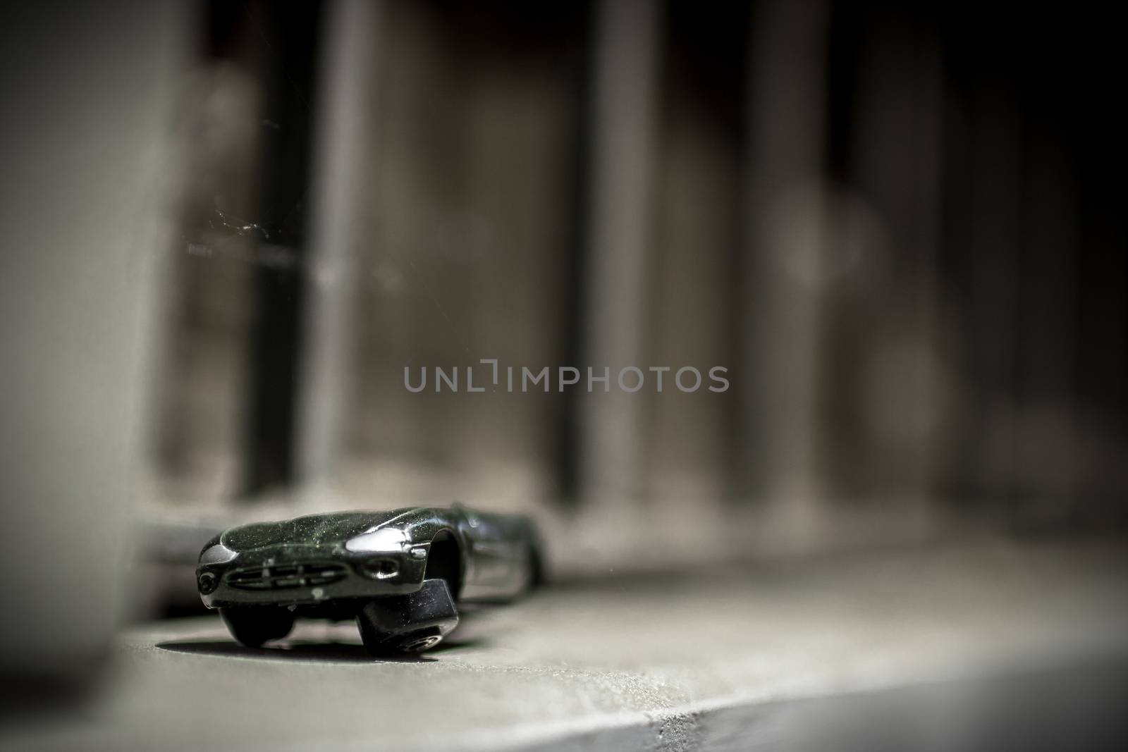 An old toy car abandoned on the street.