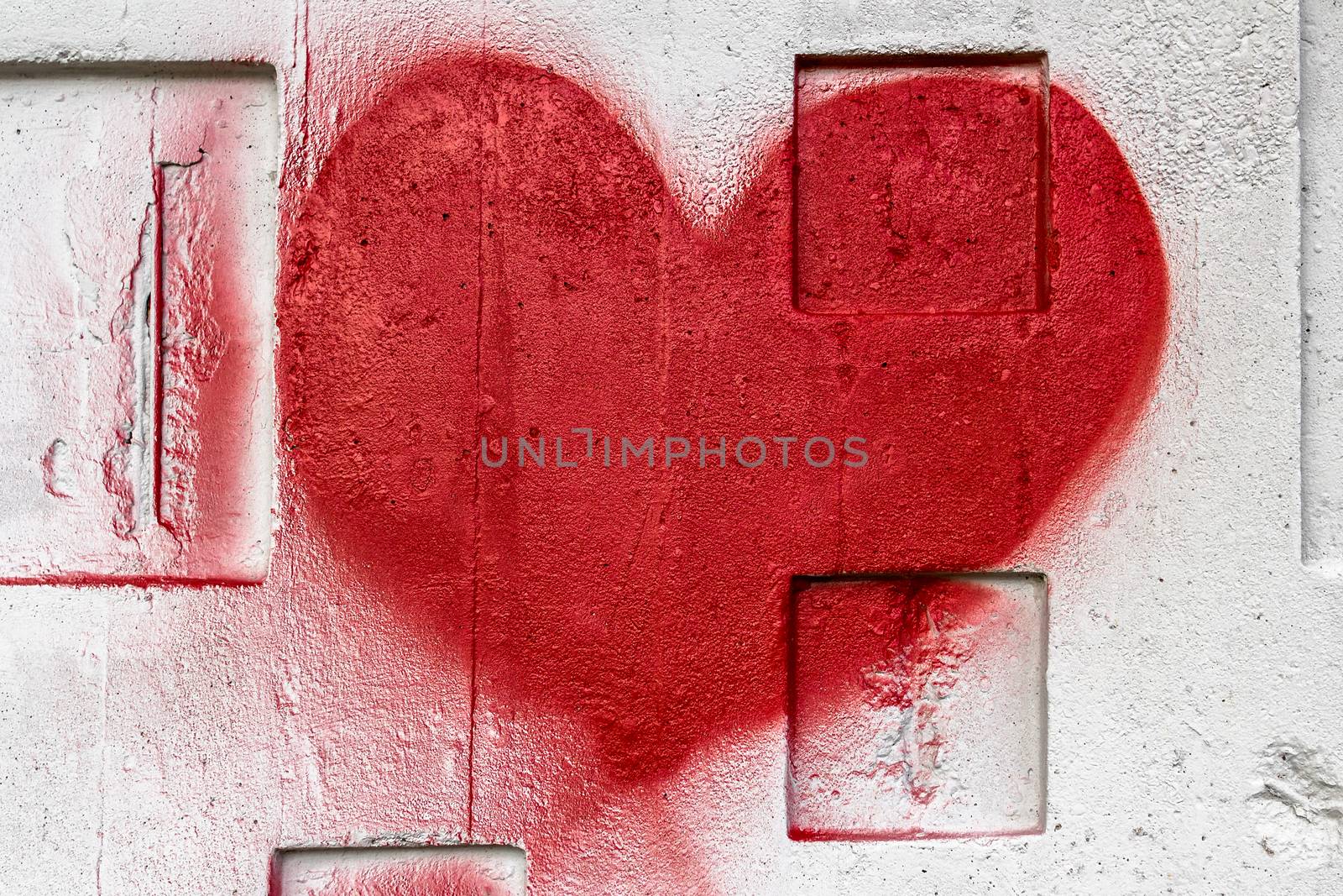 A red heart painted with love on a wall.