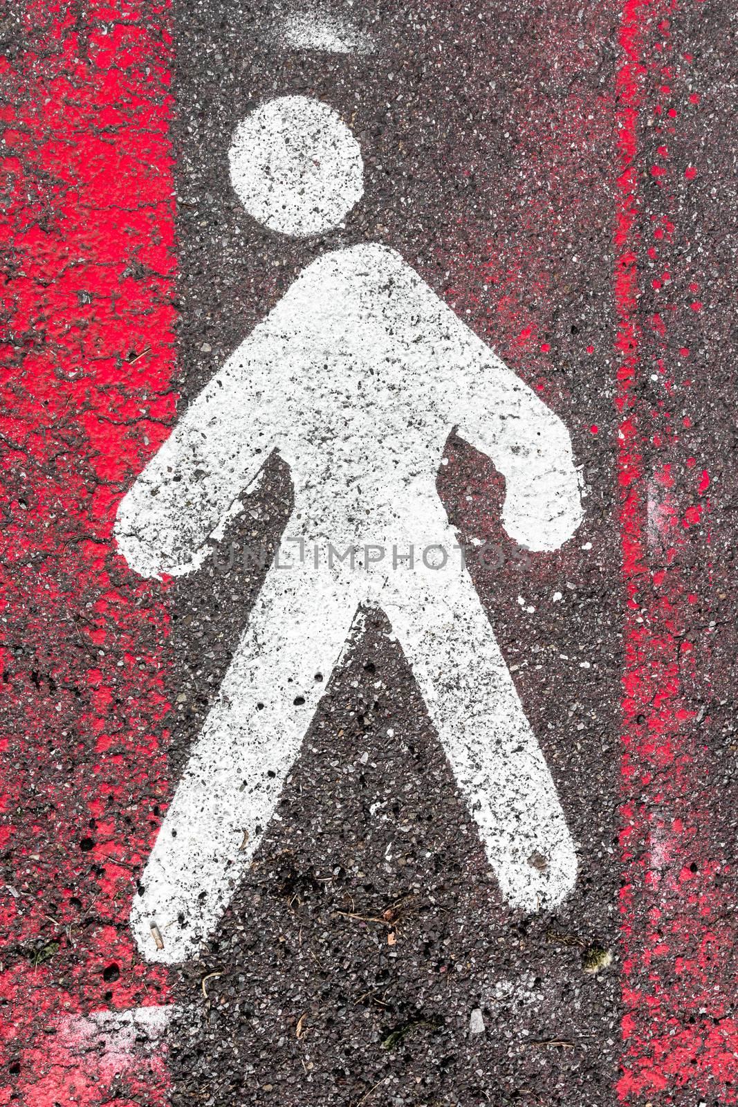 White pedestrian signal of person on asphalt, walkway pedestrian. Information and security. Faded red pedestrian stripes.