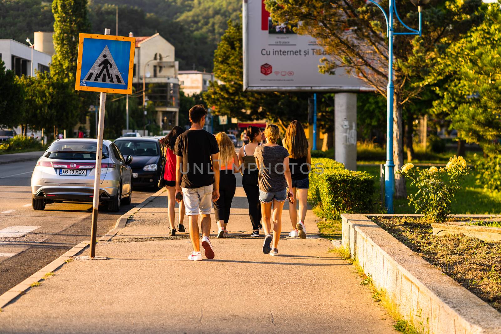 Group of teenagers walking on a street in Orsova, Romania, 2020
