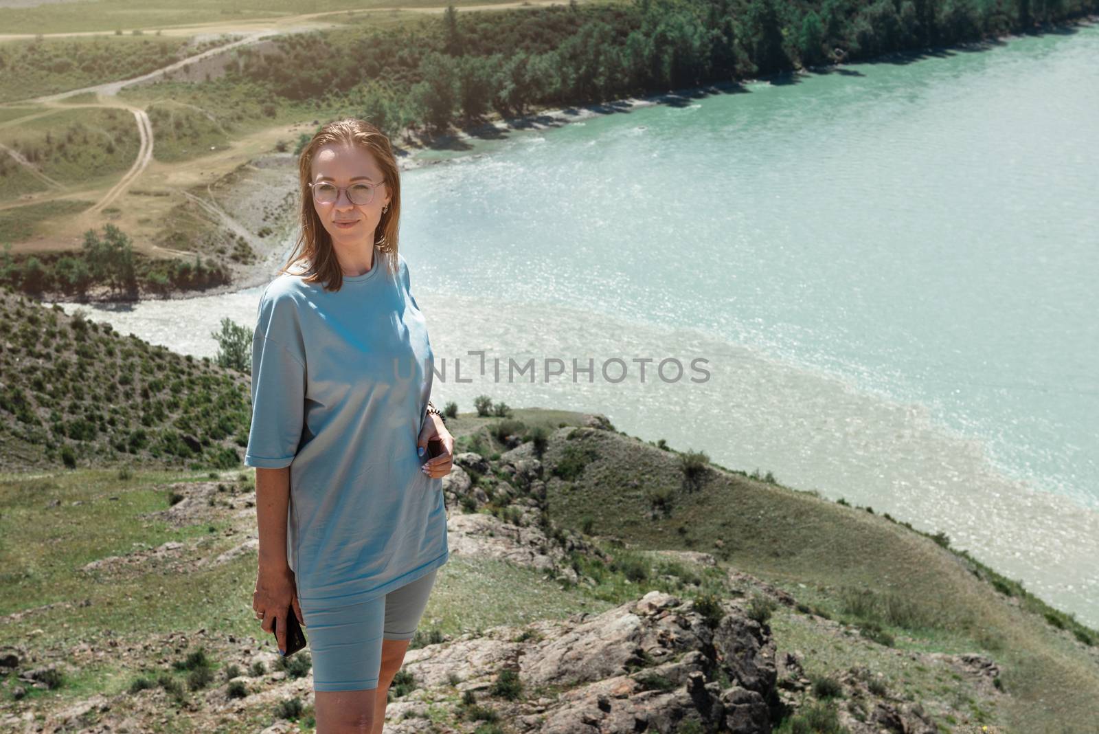 Domestic tourism, travel, lesure and freedom concept after pandemic- woman on the confluence of two rivers Katun and Chuya in Altai mountains, beauty summer day