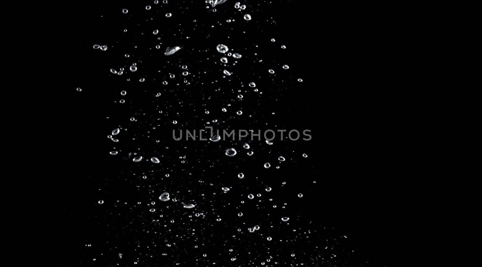 Blurred images of close-up soda water bubbles fizzing up or splashing or sparkling like a exploding of a bomb on black background for represent refreshing from carbonated drinks menu.