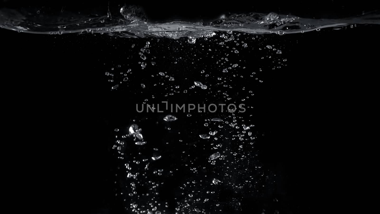 Blurred images of close-up soda water bubbles fizzing up or splashing or sparkling like a exploding of a bomb on black background for represent refreshing from carbonated drinks menu.