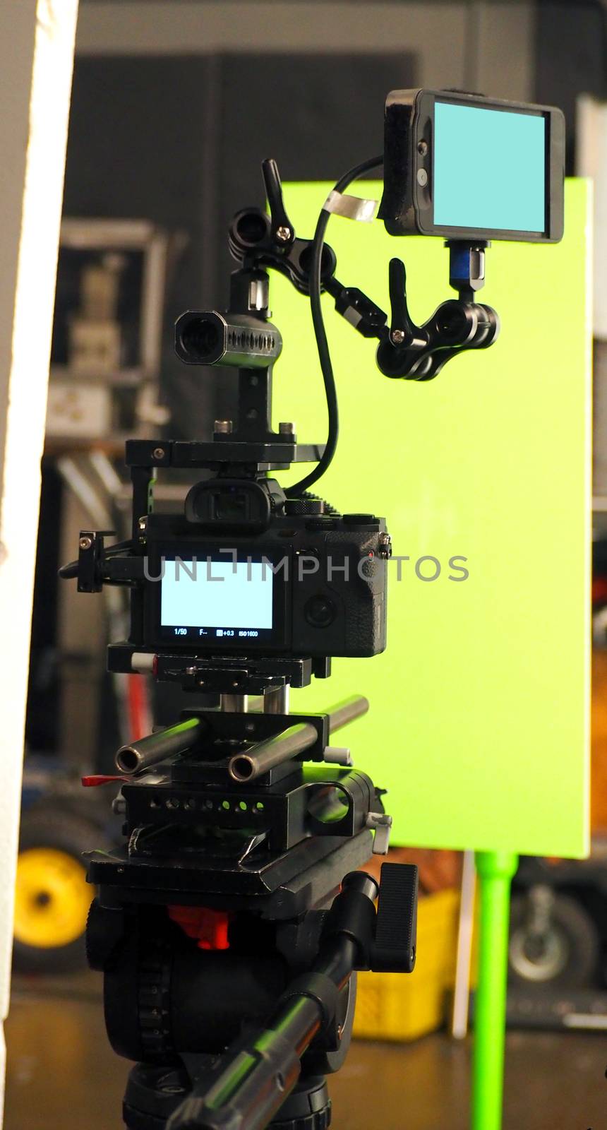 Behind the vdo camera in studio production that shooting or filming green screen background for chroma key technique in post process with professional crew teams and equipments.